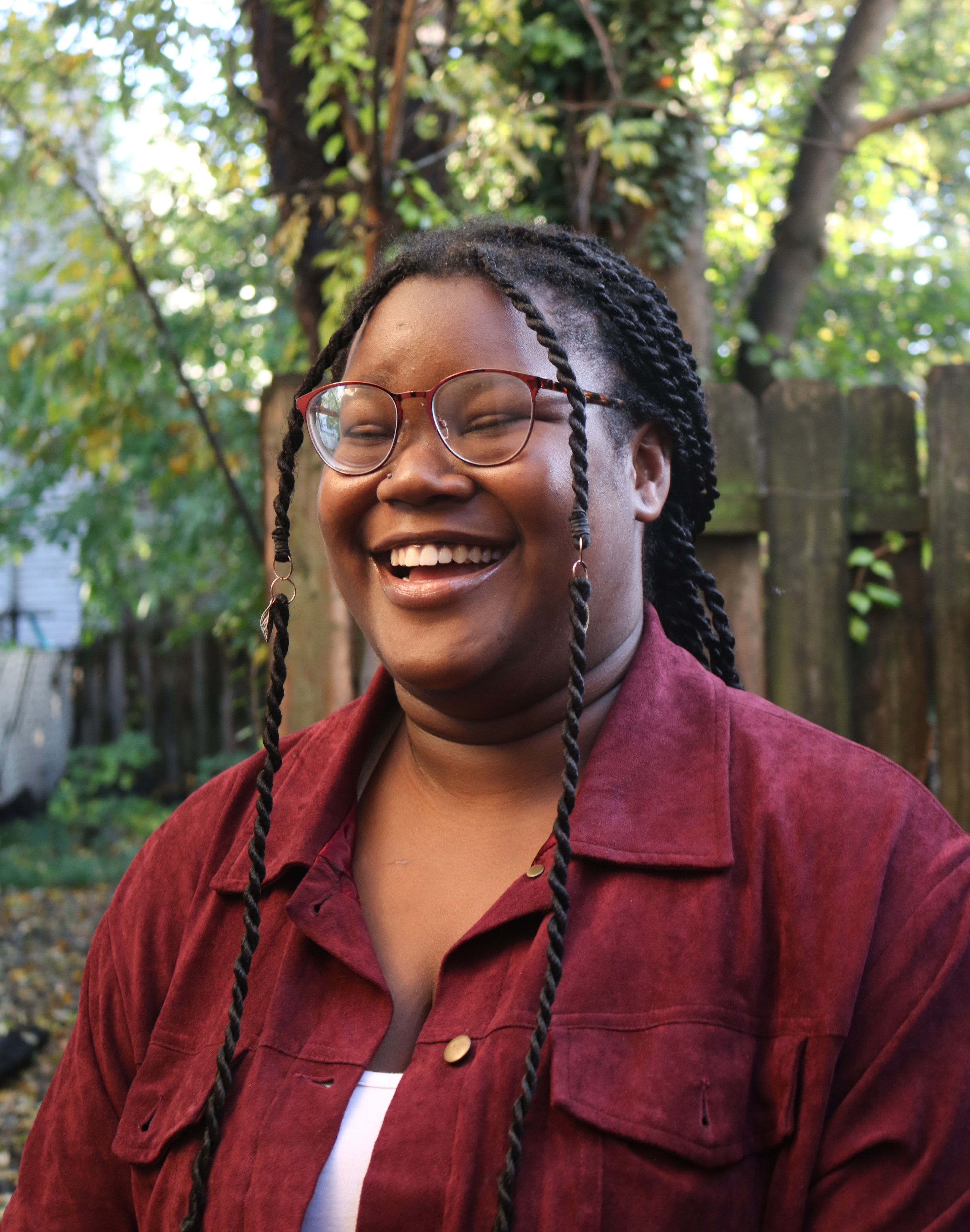 A photo of Mack wearing a graphic t-shirt and sunglasses, smirking at the camera.